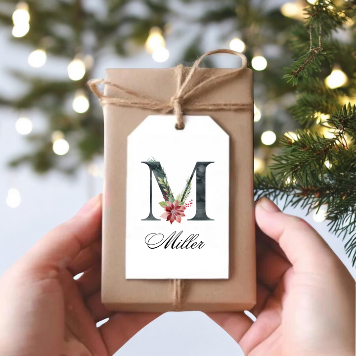 A gift tag with an initial M, lst name and poinsettia