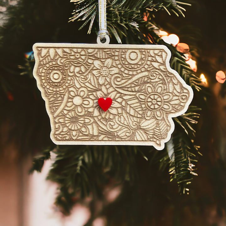 Wooden Iowa ornament with white and gold ribbon and red heart.