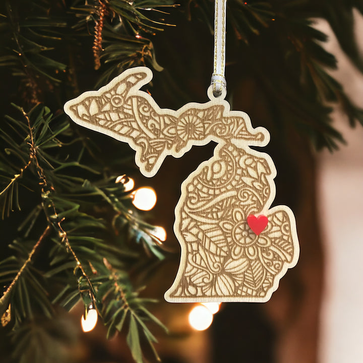 Wooden Michigan ornament with white and gold ribbon and red heart.