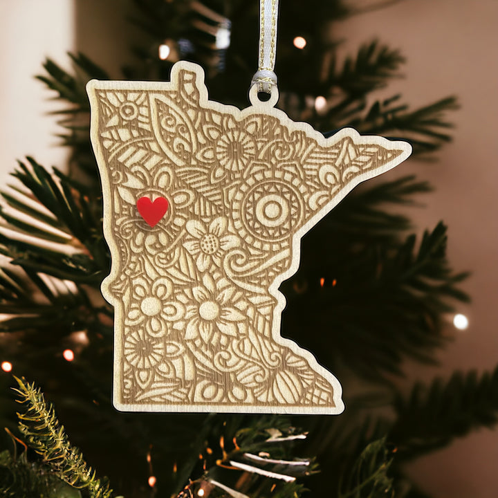 Wooden Minnesota ornament with white and gold ribbon and red heart.