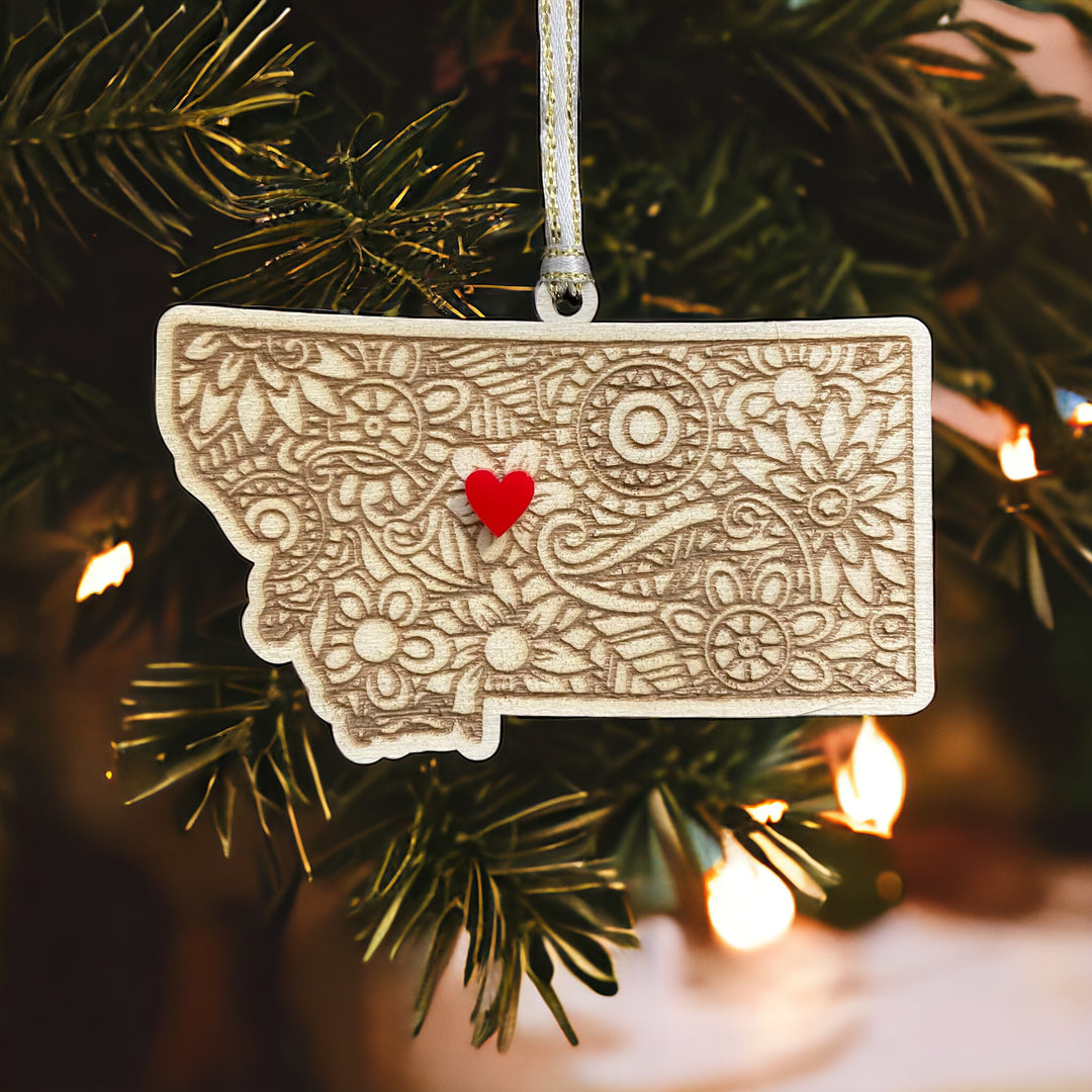 Wooden Montana ornament with white and gold ribbon and red heart.