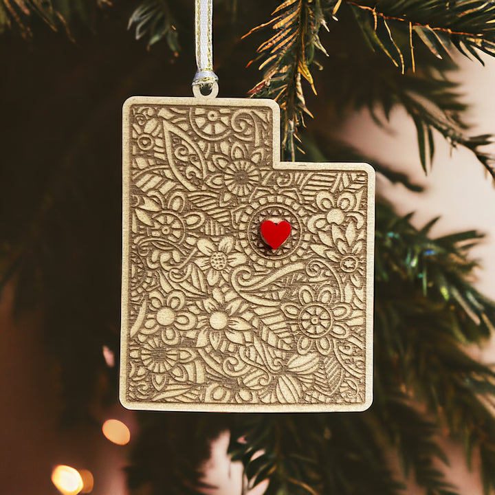 Wooden Utah ornament with white and gold ribbon and red heart.