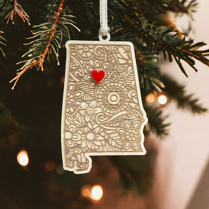 Wooden Alabama ornament with white and gold ribbon and red heart.