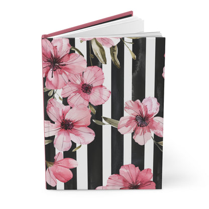 Journal with pink floral design on a black and white striped background