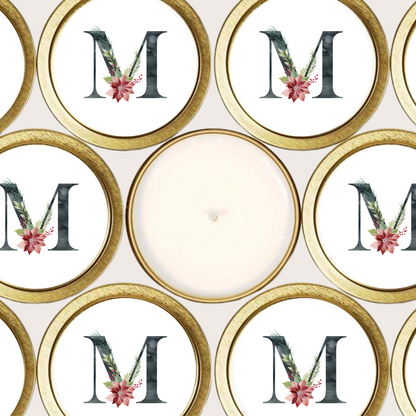 Gold candle tins with black initial and poinsettia flower.