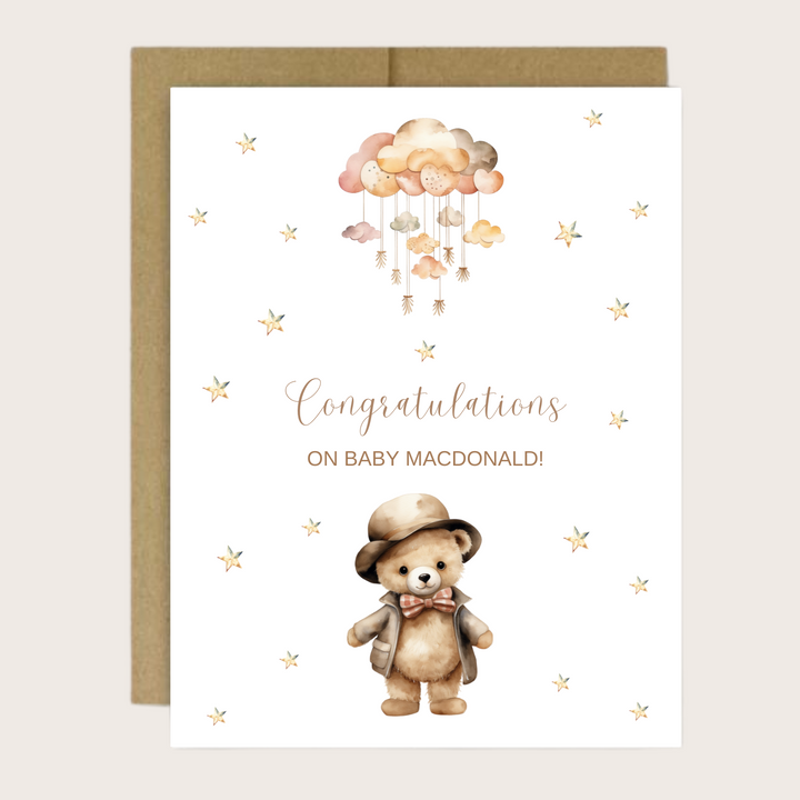 New baby card with brown teddy bear, baby  mobile and stars.