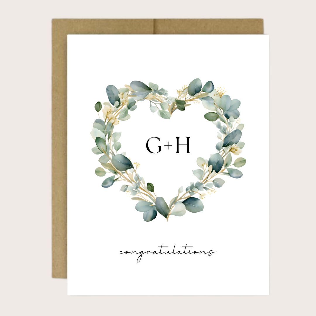 Greeting card with green eucalyptus heart shaped wreath, couple's initials and the sentiment "congratulations."