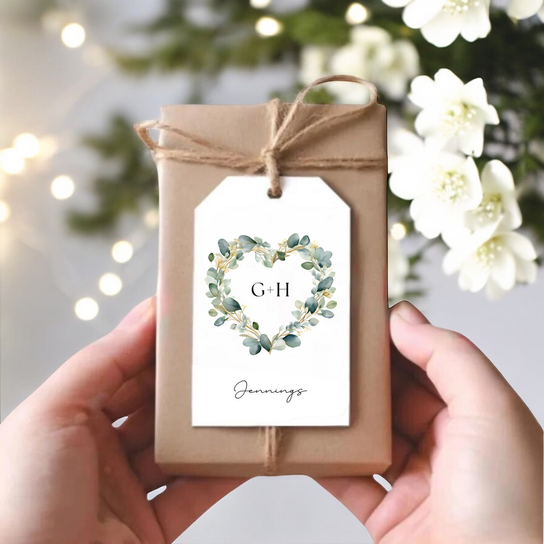 A small gift box with a eucalyptus heart with the couple's initials and last name.