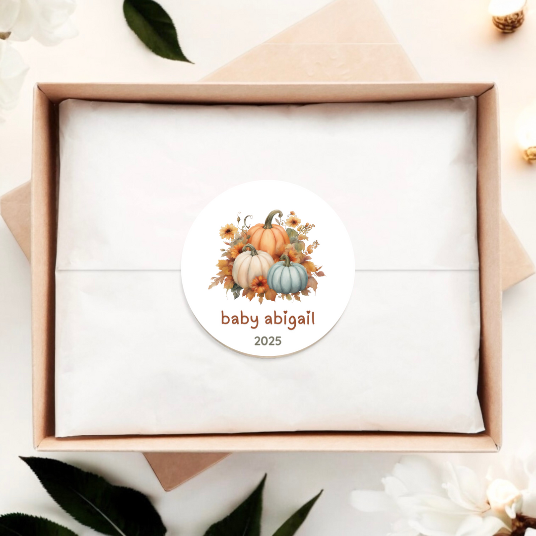 A gift box with a sticker with pumpkins and personalized baby name and year.