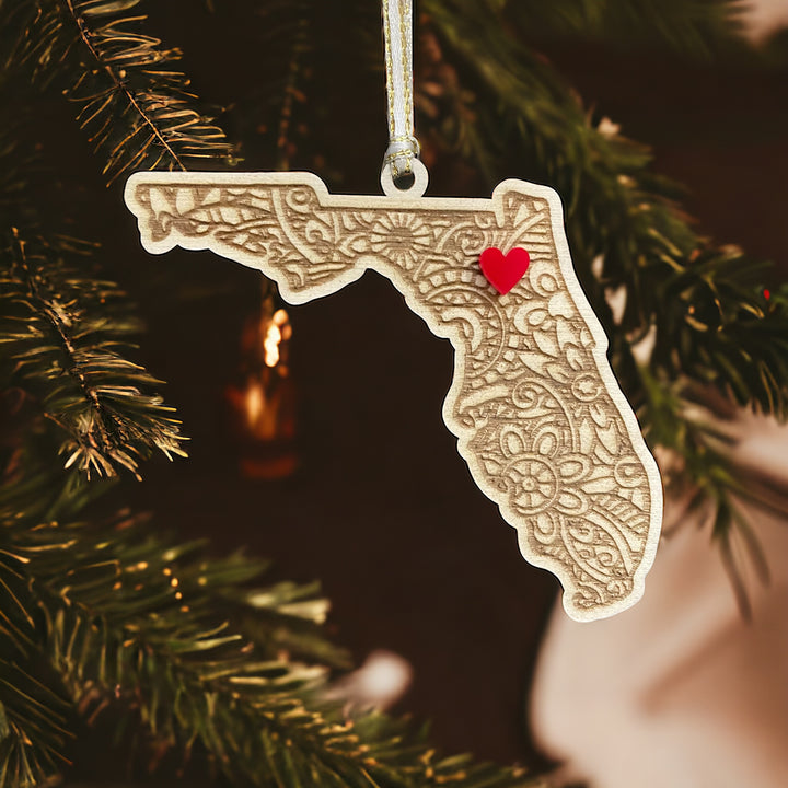 Wooden Florida ornament with white and gold ribbon and red heart.