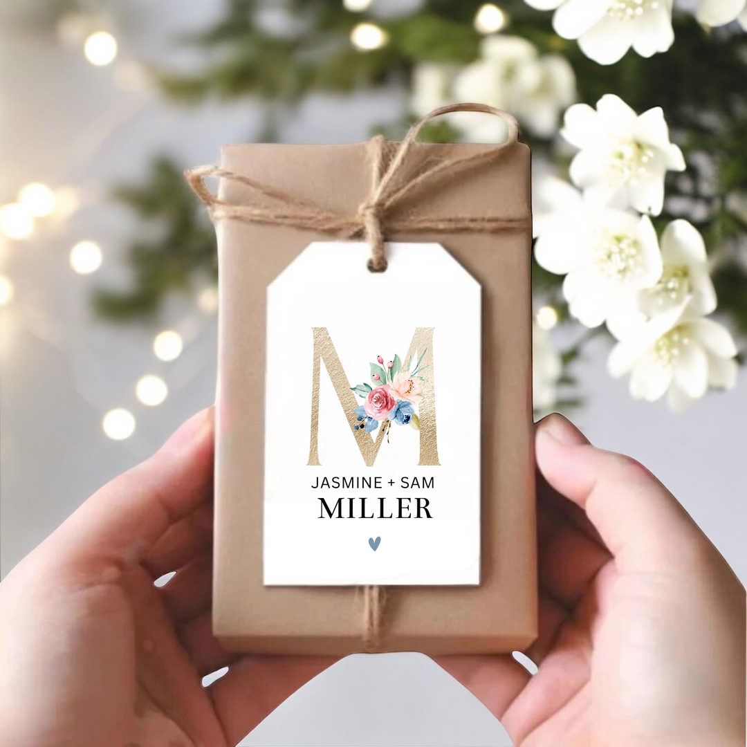 Small gift box with personalized gift tag with gold M and couple's name.