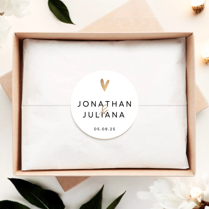 Gift box with white label sticker with gold heart, couple's name and event date.