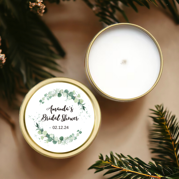 A gold tin candle with green leaves label with personalized name and date.