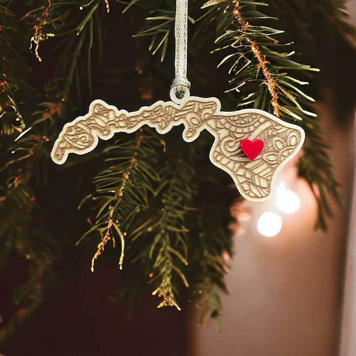 Wooden Hawaii ornament with white and gold ribbon and red heart.