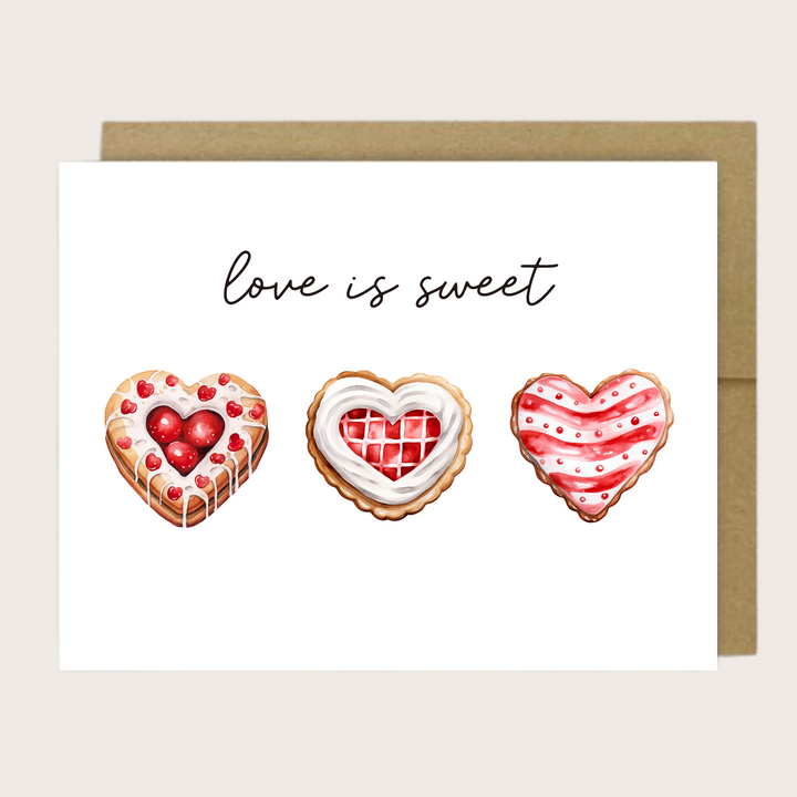 A greeting card with three heart-shaped cookies with the sentiment "love is sweet."