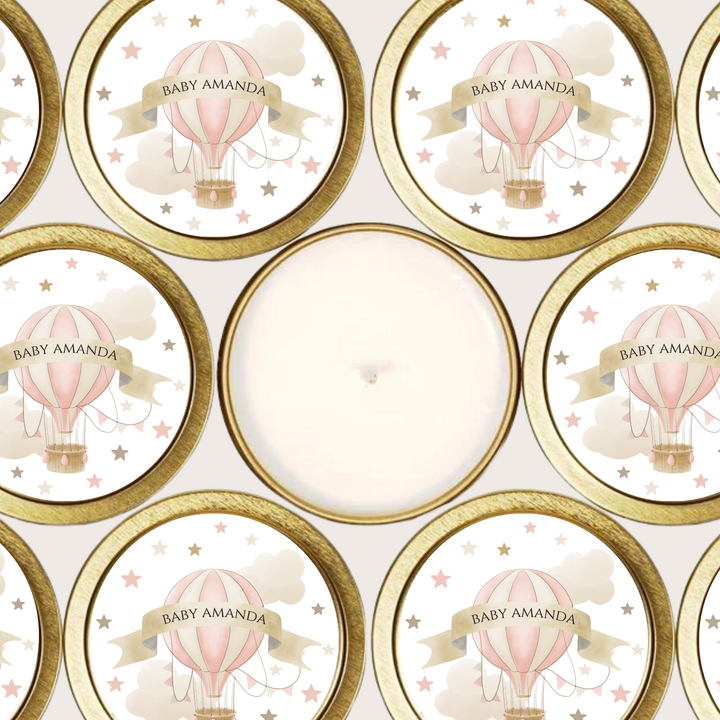 Gold tin candles with a pink hot air balloon label.