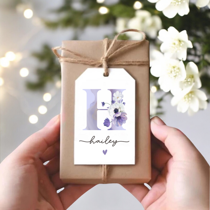 Gift box with gift tag with purple floral H and name.